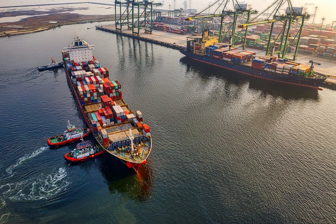 services-01 Aerial shot of cargo ships and cranes at North Jakarta port, showcasing global shipping and logistics.