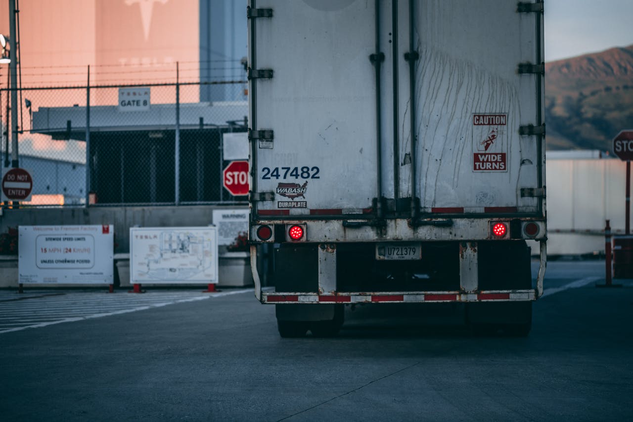 services-02 Semi truck parked at a loading dock with visible caution signs and industrial surroundings.